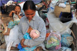 A Cambodian villager feeds her baby in a camp after fleeing from their home near the Preah Vhear temple in Preah Vihear province, some 500 kilometers northwest of Phnom Penh on 8 February 2011