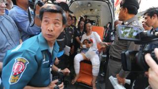 An injured Thai woman (C) receives assistance by members of a rescue team as she speaks to a Thai official, after being injured by the explosion of a taxi boat engine, at Wat Thep Leela pier in Bangkok, Thailand, 05 March 2016