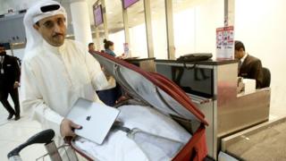 Mwanaharakati wa Kuwait Thamer Bourashed akiweka laptopu yake ndani ya mzigo kabla ya kuabiri ndege