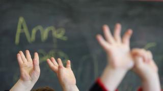 Children wave their hands at a private nursery school January 28, 2005 in Glasgow, Scotland.