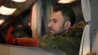 A refugee sits inside a bus arriving from the Bavarian town of Landshut at the Chancellery building in Berlin, Germany, January 14, 2016.