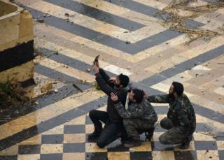 Syrian pro-government forces take a selfie in the courtyard of the ancient Umayyad mosque in the old city of Aleppo
