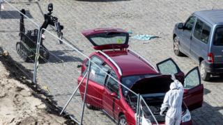 A forensics expert stands next to a car which had entered the main pedestrian shopping street in the city at high speed, in Antwerp, Belgium, 23 March 2017