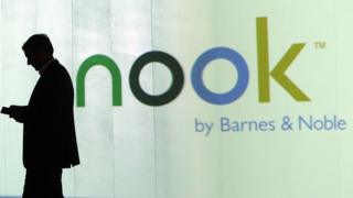 man standing outside Nook advert
