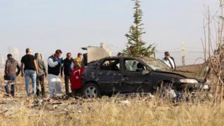 Turkish police forensic experts examine a car after a blast by two militants in Haymana, near Ankara (8 Oct)