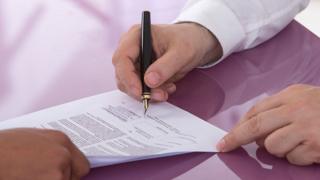 Person signing a contract for employment