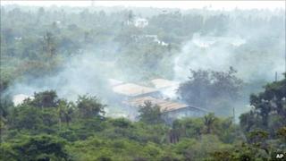 Smoke drifts over the Gongola Mboto military camp on the outskirts of Dar es Salaam Thursday Feb. 17, 2011