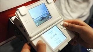 A girl playing a Nintendo DS (Photo by BERTRAND LANGLOIS/AFP/Getty Images)