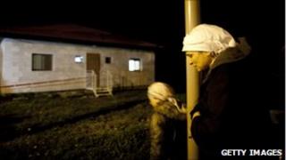 Neighbours mourn outside the Fogel family home