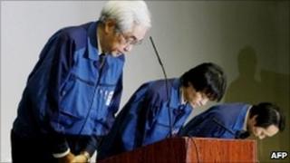 Tokyo Electric Power vice-president Sakae Muto and the company employees bow their heads