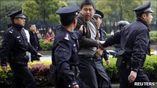 Policemen arrest a man after he threw rocks at a truck, as truck drivers continue with their third day of strike near a port area in Shanghai April 22, 2011.