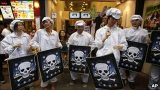 Protesters dressed as Foxconn workers demonstrate for better working conditions in Hong Kong