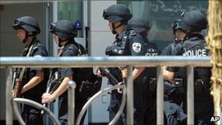 Armed members of Chinese Special Police Corps stand guard near the site of Sunday's attack in Kashgar