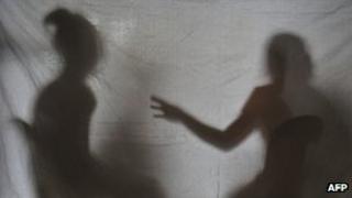 The silhouettes of two teenage girls rescued from a cyber sex den in Olongapo City, the Philippines, December 2010