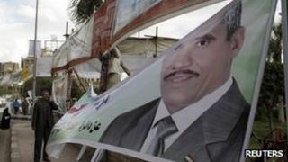 An election worker hangs a candidate's poster in Cairo - 14 November 2011