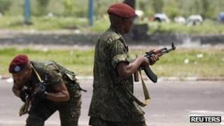 A member of the presidential guard fires into a crowd of opposition UDPS supporters outside N'Djili airport in Kinshasa November 26, 2011.