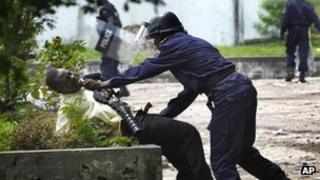 A police officer grabs a supporter of Etienne Tshisekedi in Kinshasa, DR Congo (8 Dec 2011)