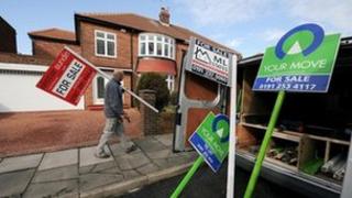 Man erecting "for sale" signs