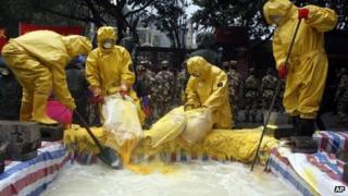 Policemen in chemical suits pouring neutralisers into water tainted by cadmium pollution in Nuomitan Reservoir in Liucheng county in China's Guangxi Zhuang Autonomous Region, on 30 January, 2012
