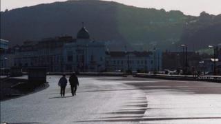 Couple stroll on Llandudno promenade