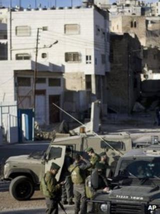 Israeli soldiers stand outside the house in the West Bank city of Hebron, which Jewish settlers have been asked to leave (3 April 2012)