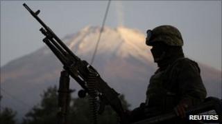Mexican soldier on truck with machine gun in Puebla, with Popocatepetl volcano in the background