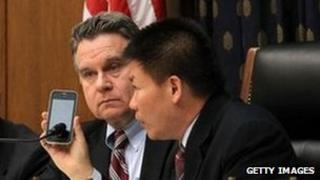 US Rep Chris Smith (2nd L), Rep Frank Wolf (L) and president of ChinaAid Bob Fu (R) listen to Chen Guangcheng on the phone during a hearing of the Congressional-Executive Commission on China on 3 May 2012 in Washington, DC