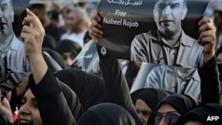 A female demonstrator holding Nabeel Rajab's picture