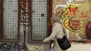 Woman walks past closed shop in Madrid