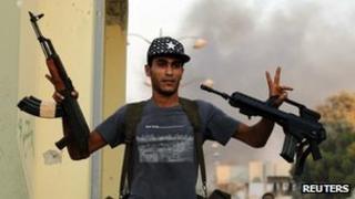 A rebel makes the victory sign in August 24 2011