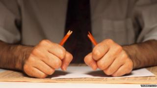 Man snapping pencil in half