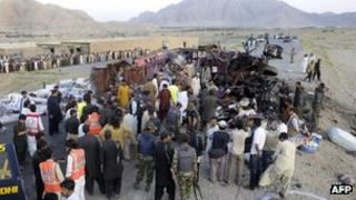 Pakistani security officials examine the wreckage of a destroyed bus after a bomb explosion on the outskirts of Quetta on June 28, 2012.