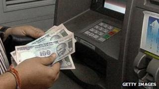 A man uses a cash point in India