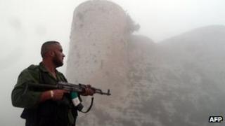 A member of the Free Syrian Army stands near the "Al-Hosn" Crusaders Citadel on the outskirts of flashpoint city of Homs