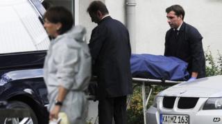 A body is taken from a building in Karlsruhe after five people died in a siege (4 July 2012)