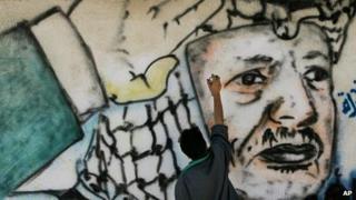 A Palestinian artist finishes a mural of Yasser Arafat near his head quarters in Gaza City
