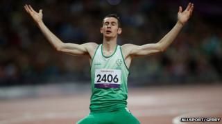 Michael McKillop kneels on the track after winning gold