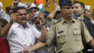 A policeman tries to stop activists of India Against Corruption protesting against the arrest of political cartoonist Aseem Trivedi, outside the jail where he is being held in Mumbai, 11 Sept 2012