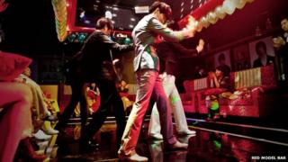 Male hosts dance at the Red Model Bar in Seoul, South Korea