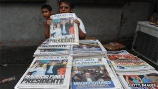 A woman sells newspapers in downtown of San Salvador