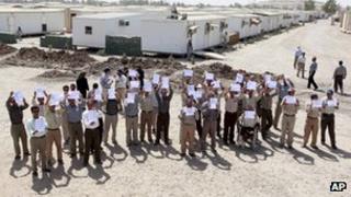 Members of the Mujahideen-e-Khalq hold banners during a tour organised by the Iraqi government for foreign diplomats in Baghdad on 11 Sep 2012.