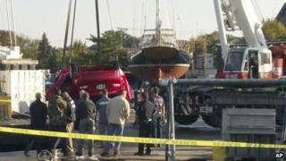 The red car is lifted out of the water