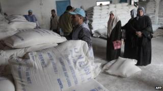 Women wait for flour rations from Unrwa at a refugee camp in Gaza City