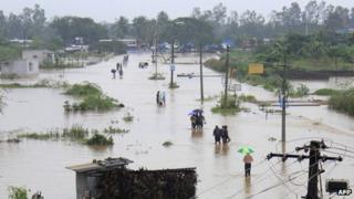 Indian residents wade through flood waters in Visakhapatnam in the coastal district of Andhra Pradesh on November 5, 2012