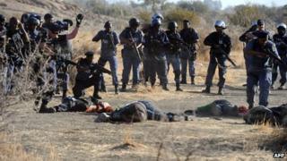 police aiming at miners laying on the ground after police opened fire during clashes near the Marikana platinum mine