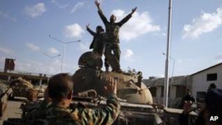 Syrian fighters celebrate after storming a military base in Aleppo on 19/11/12