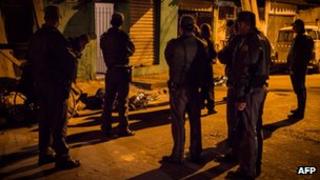 Police inspect the bodies of two men killed in the streets of Sao Paulo last week