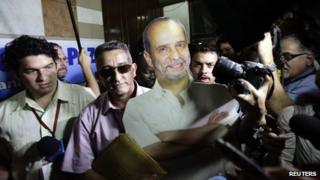 Farc delegate Ruben Zamora (centre, in sunglasses) carries a life-size cardboard cut-out of imprisoned guerrilla Simon Trinidad before talks in Havana, Cuba, 19 November 2012