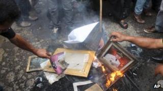 Protesters burn portraits of Garut District Chief Aceng Fikri during a protest in the town of Garut, West Java, Indonesia, Tuesday, Dec. 4, 2012.