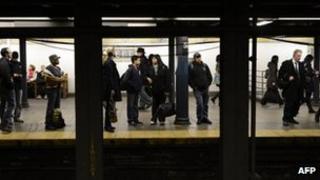 Commuters wait at the 59th Street subway station in this 1 November 2012 file photo in New York